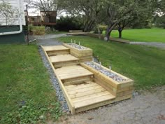 some steps made out of wood and gravel in front of a house on the grass