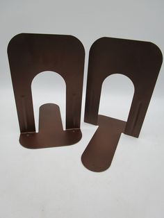 two pieces of metal sitting next to each other on a white surface with no background