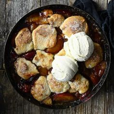 an apple cobbler with ice cream on top in a skillet, ready to be eaten