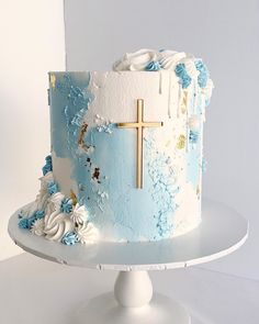 a blue and white cake with a cross on top