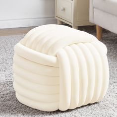 an inflatable chair sitting on the floor next to a white dresser with drawers