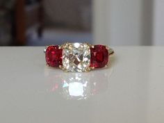 three stone diamond and ruby ring on white surface