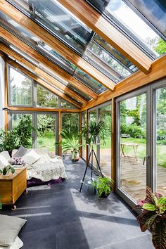 a room filled with lots of windows and plants