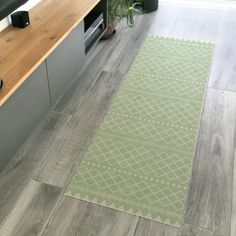 a green rug in the middle of a kitchen with an oven and microwave on it