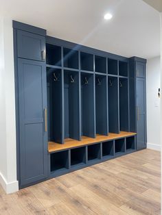 an empty room with several blue lockers and wooden flooring on the side wall