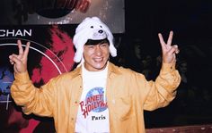 a man in a bunny hat is making the peace sign with his hands and smiling