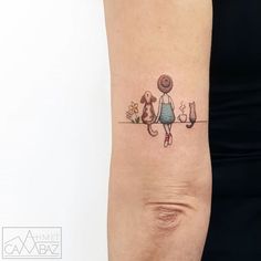 a woman's arm with a tattoo on it that has an image of two cats