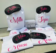 three personalized eye masks are on the counter next to two bags with their names