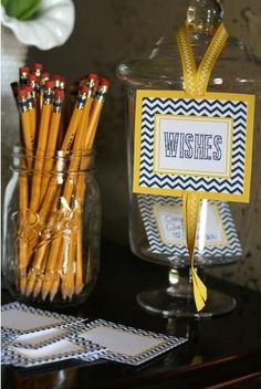 some yellow and black pencils are sitting on a table next to a glass jar