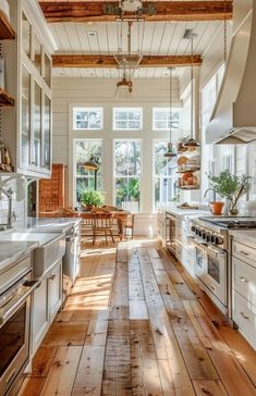 an open kitchen with wooden floors and white cabinets is pictured in this image from the inside