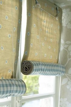 two curtains hanging from the side of a window