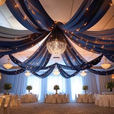 an elegant ballroom with chandeliers and blue drapes