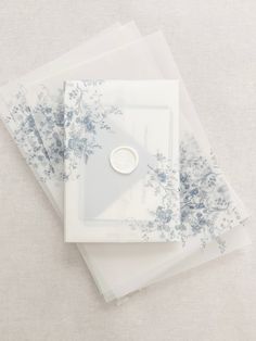 three sheets of clear plastic with blue flowers on them and a button in the middle