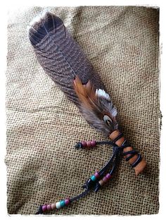 a feather and beaded necklace laying on the ground