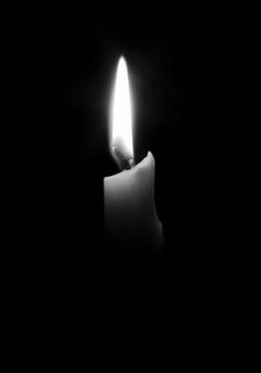 a candle is lit in the dark with only one light on it's side