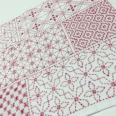 two red and white designs on a white table cloth, one is made out of fabric