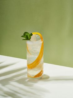 an orange and white drink sitting on top of a table next to a green wall