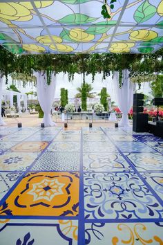 an elaborately decorated dance floor with white drapes and floral decorations on the ceiling