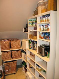 an organized pantry with lots of food in baskets and containers on shelving unit shelves