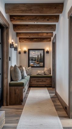 a long hallway with two benches and pillows on the floor, along with wooden beams