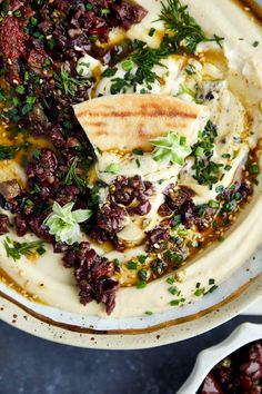 a white bowl filled with food and garnished with herbs