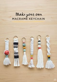 macrame keychains with tassels are arranged on a wooden surface