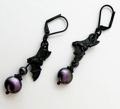 Irridescent Purple Swarovski Pearl and Black Bat Dangle Earrings Purple Pearl Earrings Gothic Bat Dangle Earrings These are quite awesome if I do say so myself! I was so fortunate to find a few Swarovski Purple Coin Pearls. These are almost distinct now. I paired these gorgeous coin pearls with smaller round pearls and fantastic Tierracast Black Pewter bats! All high quality pieces here right down to the jump ring connectors! Black lever ear wires connect these all together. The beauty of these Swarovski pearls is hard to catch fully on camera. Gothic and/or horror related jewelry does not have to be junky and cheap. I think you will love these as much as I do and if you don't return them and I'll just keep them for myself :) FREE SHIPPING AND GIFT BOX INCLUDED Designed and assembled by Wi Antique Silver Necklace, Lavender Earrings, Dragonfly Bracelet, Earrings Gothic, Ombre Earrings, Bat Earrings, Black Earrings Dangle, Swarovski Bracelet, Gothic Necklace