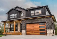 a two story house with wood garage doors