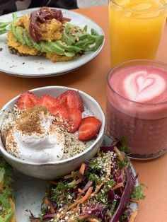 a table topped with plates of food next to glasses of orange juice and strawberries