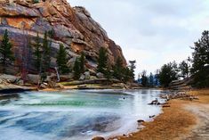 the water is crystal blue and green in this rocky area with trees on either side