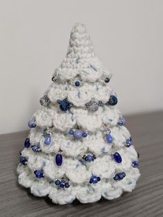 a white crocheted christmas tree with blue beads