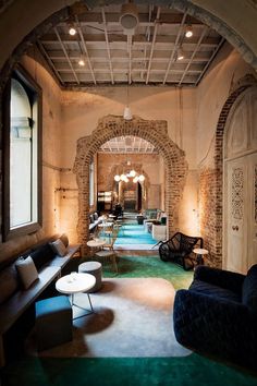 a living room filled with furniture and a stone archway leading to an indoor swimming pool