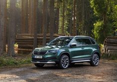 a green suv is parked in the woods