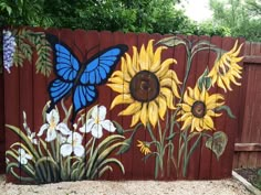 a painted fence with sunflowers and butterflies on it