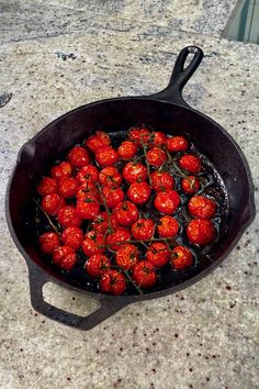 a pan filled with lots of tomatoes on top of a counter