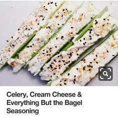 several pieces of celery on a white plate with black sesame seeds and seasoning