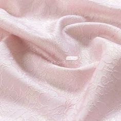 a pink fabric with white lace on it