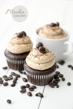 two cupcakes with chocolate chips on top and coffee beans all around the edges