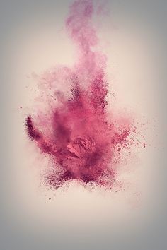 pink powder exploding in the air on a gray background