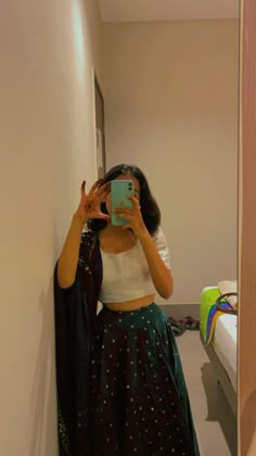 a woman taking a selfie while wearing a skirt