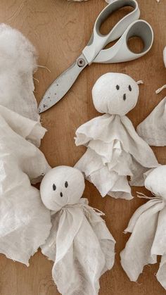 several pieces of cloth with faces and eyes on them next to scissors, paper towels and other crafting supplies