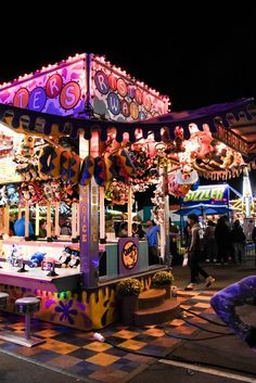 an amusement park at night with people walking around