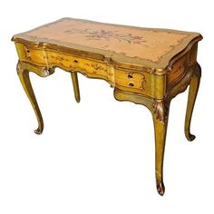 an old wooden table with floral designs painted on the top and drawer at the bottom