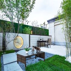 an outdoor living area with table, chairs and planter in the middle of it