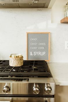 a stove top oven sitting inside of a kitchen next to a sign that says candy canes candy corn and syrup