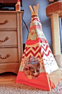 a teepee with a cat on it sitting in front of a dresser