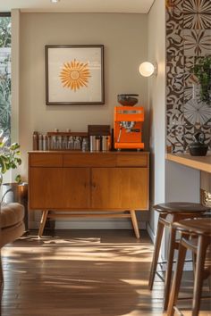 an orange machine sitting on top of a wooden cabinet in a living room next to a window