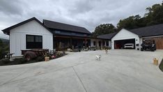 a dog is walking in front of a house with two garages on the other side