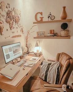 a desk with a computer, lamp and other items on it in front of a map