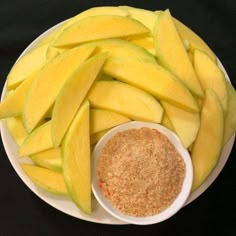 a white plate topped with sliced apples next to a bowl of seasoning on top of it